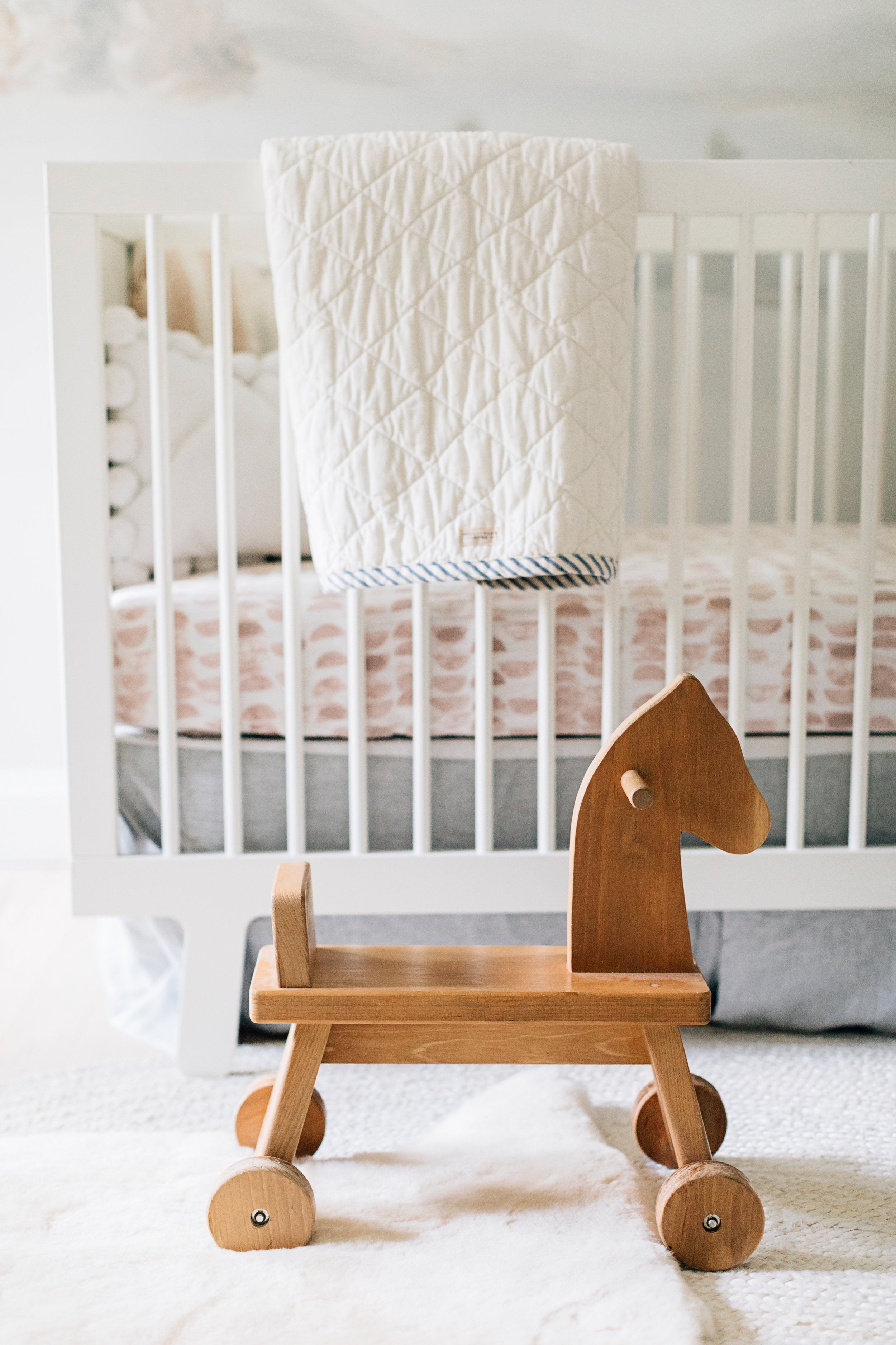 The Child's Quilted Blanket on a Crib